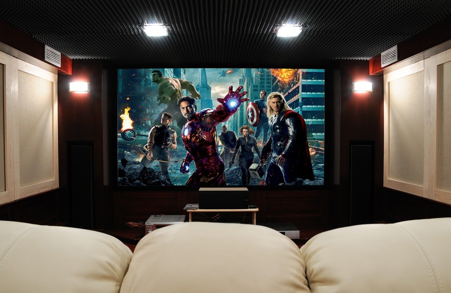 A home theater with a screen displaying the Avengers movie.