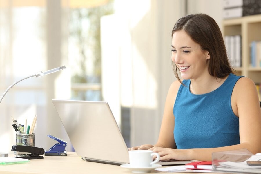 A woman at her home office desk utilizing her home network connection.