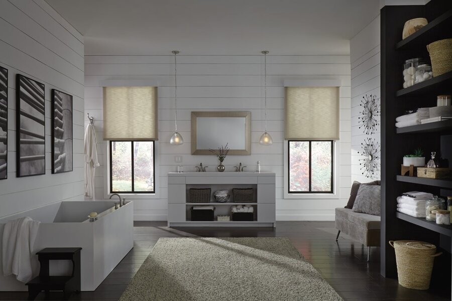 A bathroom featuring two windows with motorized shades lowered halfway.